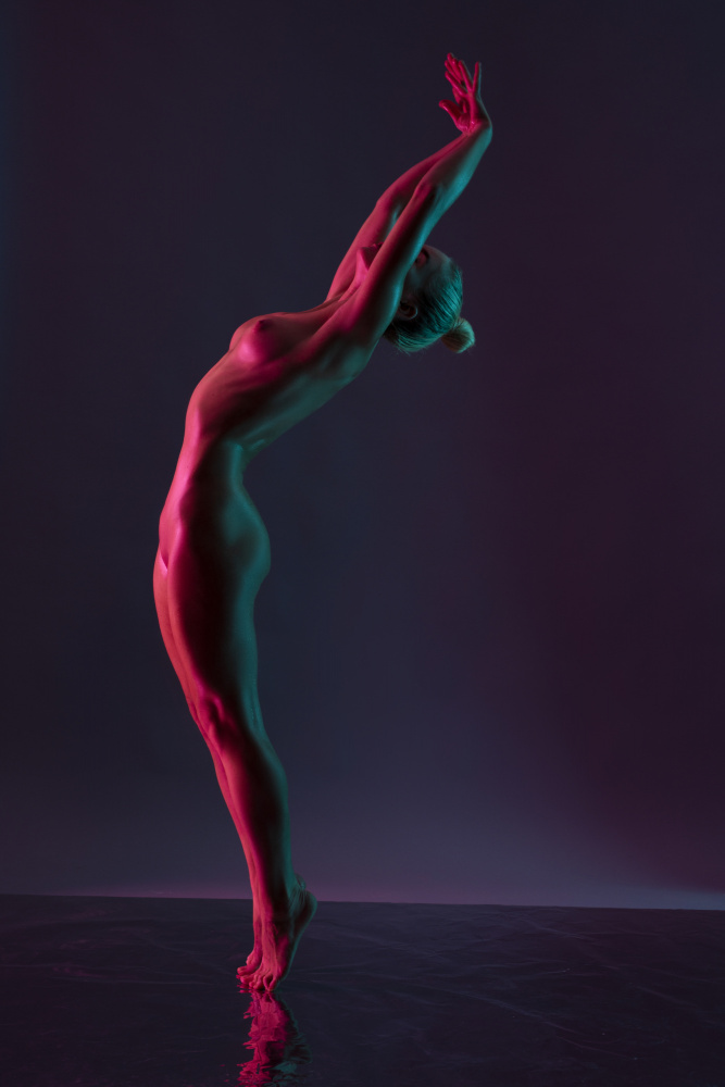 Young naked woman dance against dark purple background od Andrey Guryanov