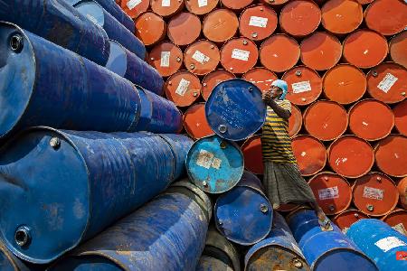 Worker sorting colorful oil drums