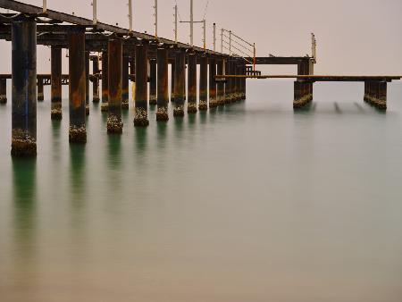 old pier on the beach and long exposure sea waves