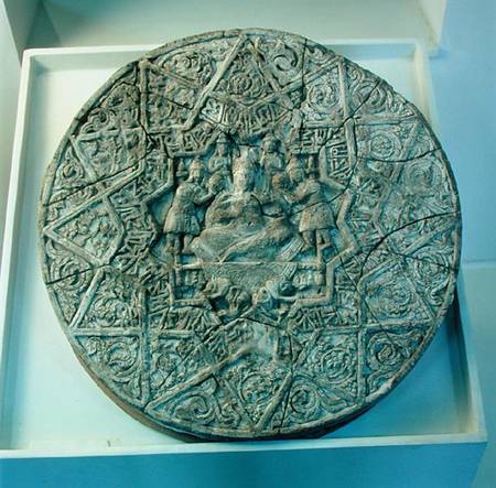 Sun disc depicting a king sitting cross-legged on a throne flanked by two angels in the centre, foun od Islamic School