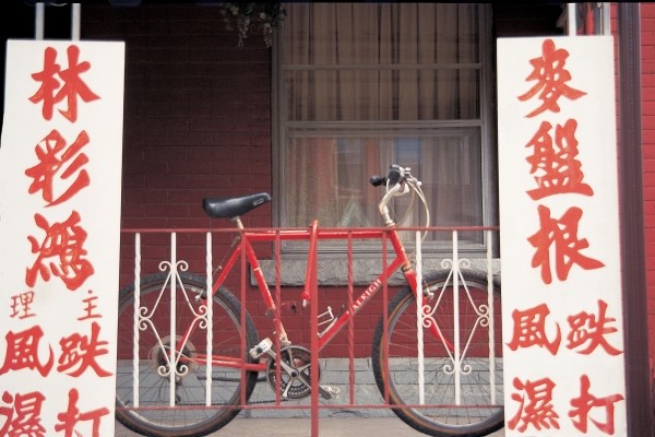 Bicycle at metal bars with Chinese board , Singapore (photo)  od 